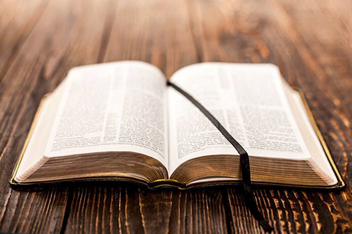 An open Bible on a wooden table